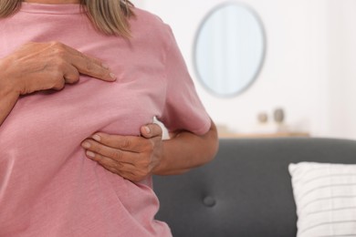 Photo of Woman doing breast self-examination at home, closeup. Space for text