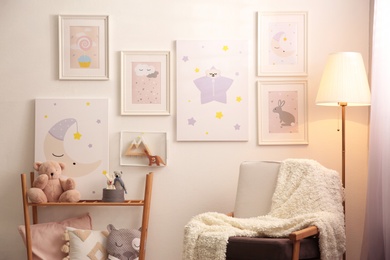Photo of Stylish child's room interior with comfortable armchair and beautiful pictures