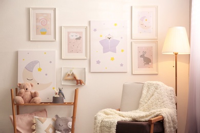 Stylish child's room interior with comfortable armchair and beautiful pictures