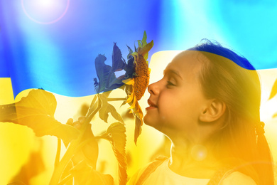 Double exposure of cute little girl with sunflower and Ukrainian flag 