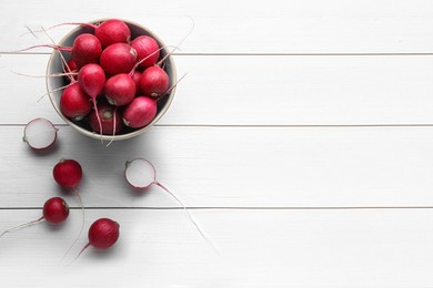 Photo of Bowl with fresh ripe radishes on white wooden table, flat lay. Space for text