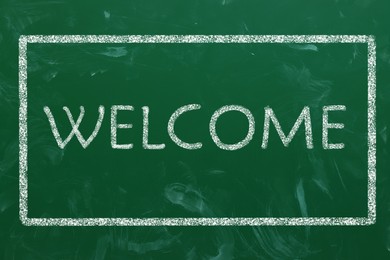 Word WELCOME written on green chalkboard, top view