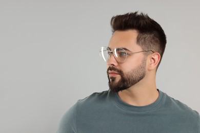 Photo of Handsome man wearing glasses on light gray background, space for text
