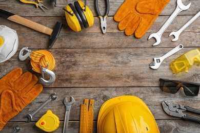 Photo of Flat lay composition with different construction tools and space for text on wooden background