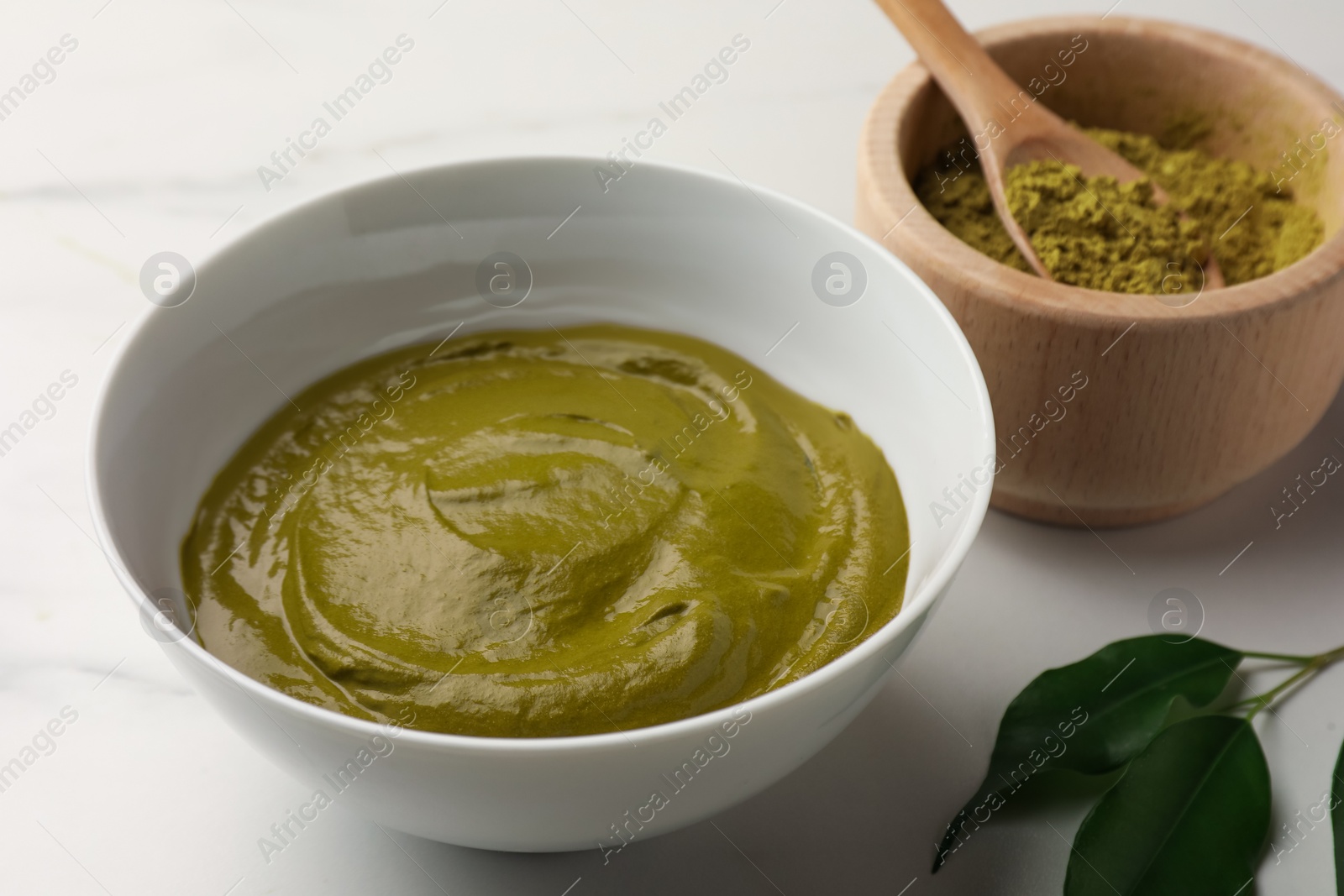 Photo of Henna cream and powder on white marble table, closeup. Natural hair coloring