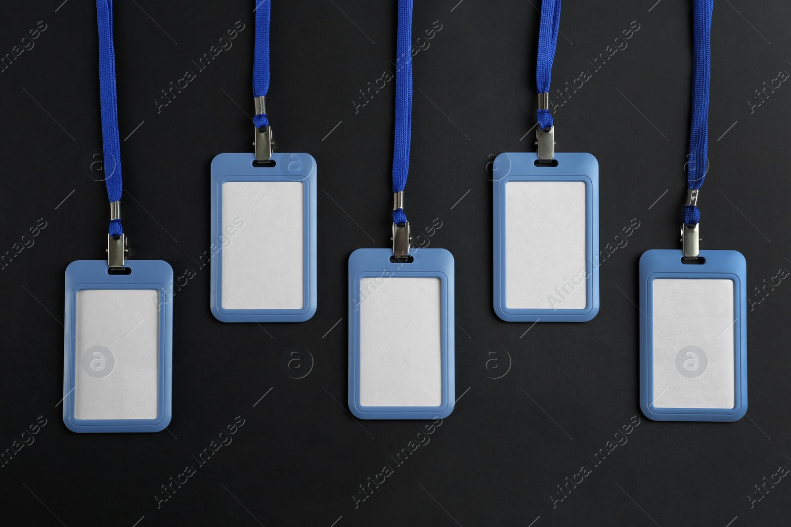Photo of Blank badges on black background, flat lay. Mockup for design