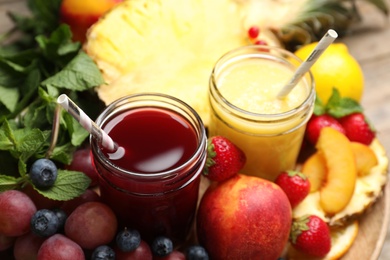 Photo of Delicious colorful juices in glasses and fresh ingredients on table, closeup