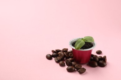 Photo of Coffee capsule, seedling and beans on pink background, space for text