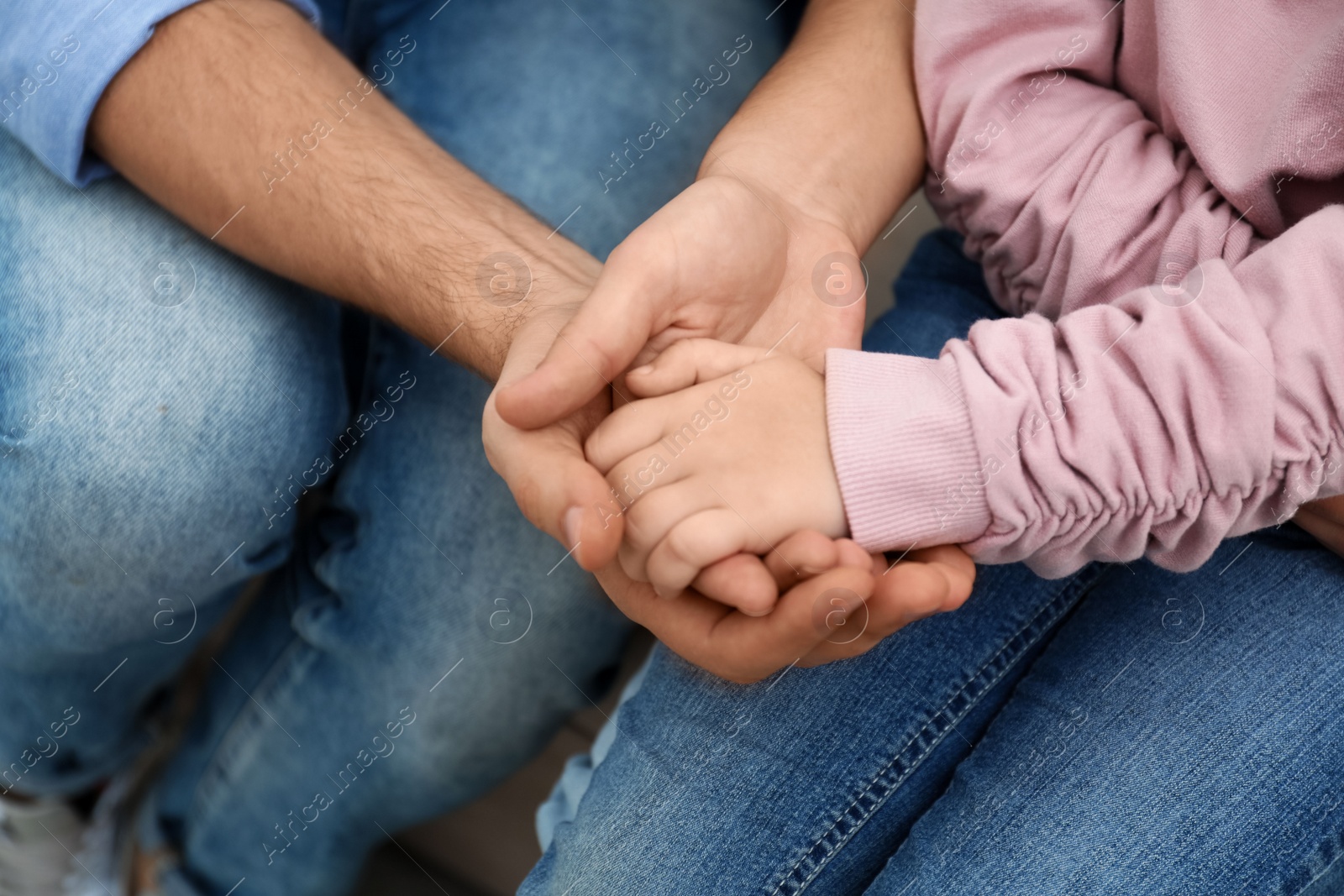 Photo of Closeup view of happy family holding hands