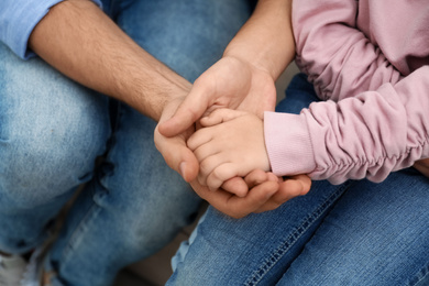 Photo of Closeup view of happy family holding hands