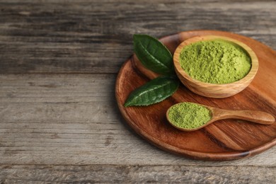 Photo of Spoon and bowl with green matcha powder on wooden table. Space for text