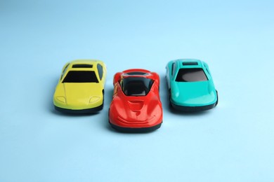 Photo of Different bright cars on light blue background. Children`s toys