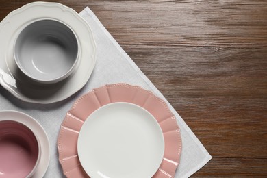 Beautiful ceramic dishware on wooden table, top view. Space for text