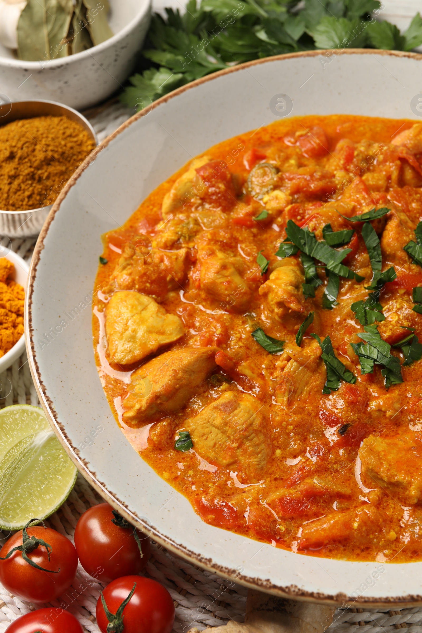 Photo of Delicious chicken curry and ingredients on table