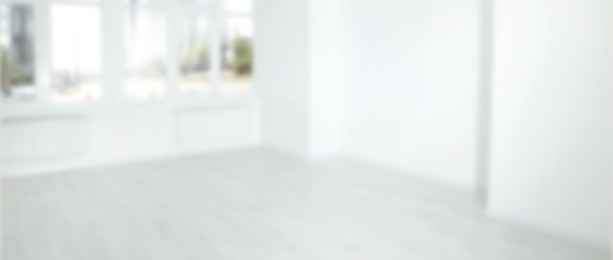 Empty room with white wall and large window, blurred view. Banner design