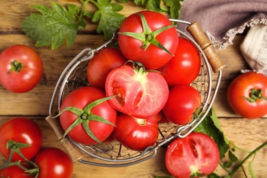 Photo of Fresh ripe tomatoes with leaves on wooden table, flat lay