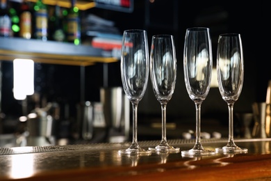 Empty clean champagne glasses on counter in bar. Space for text