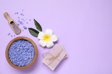 Beautiful spa composition with sea salt on violet background, flat lay. Space for text