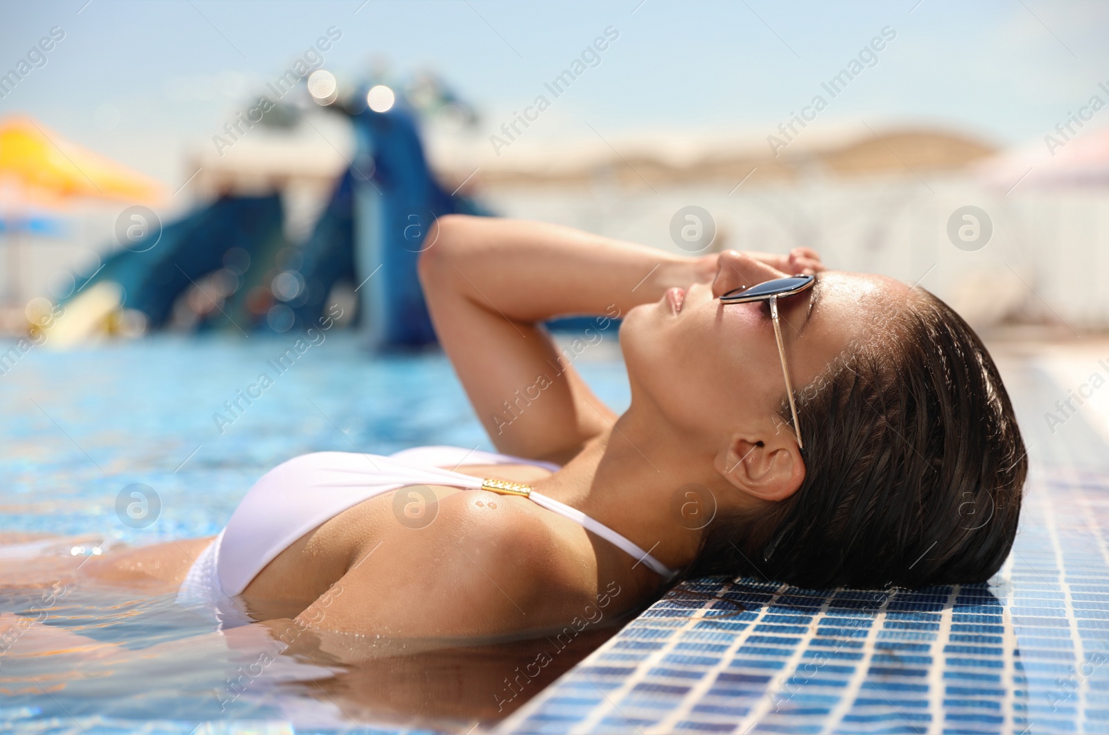 Photo of Young woman in outdoor swimming pool. Summer vacation