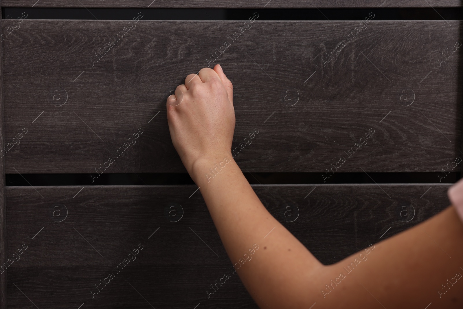 Photo of Woman knocking on door indoors, closeup view