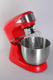 Photo of Modern red stand mixer on light gray background