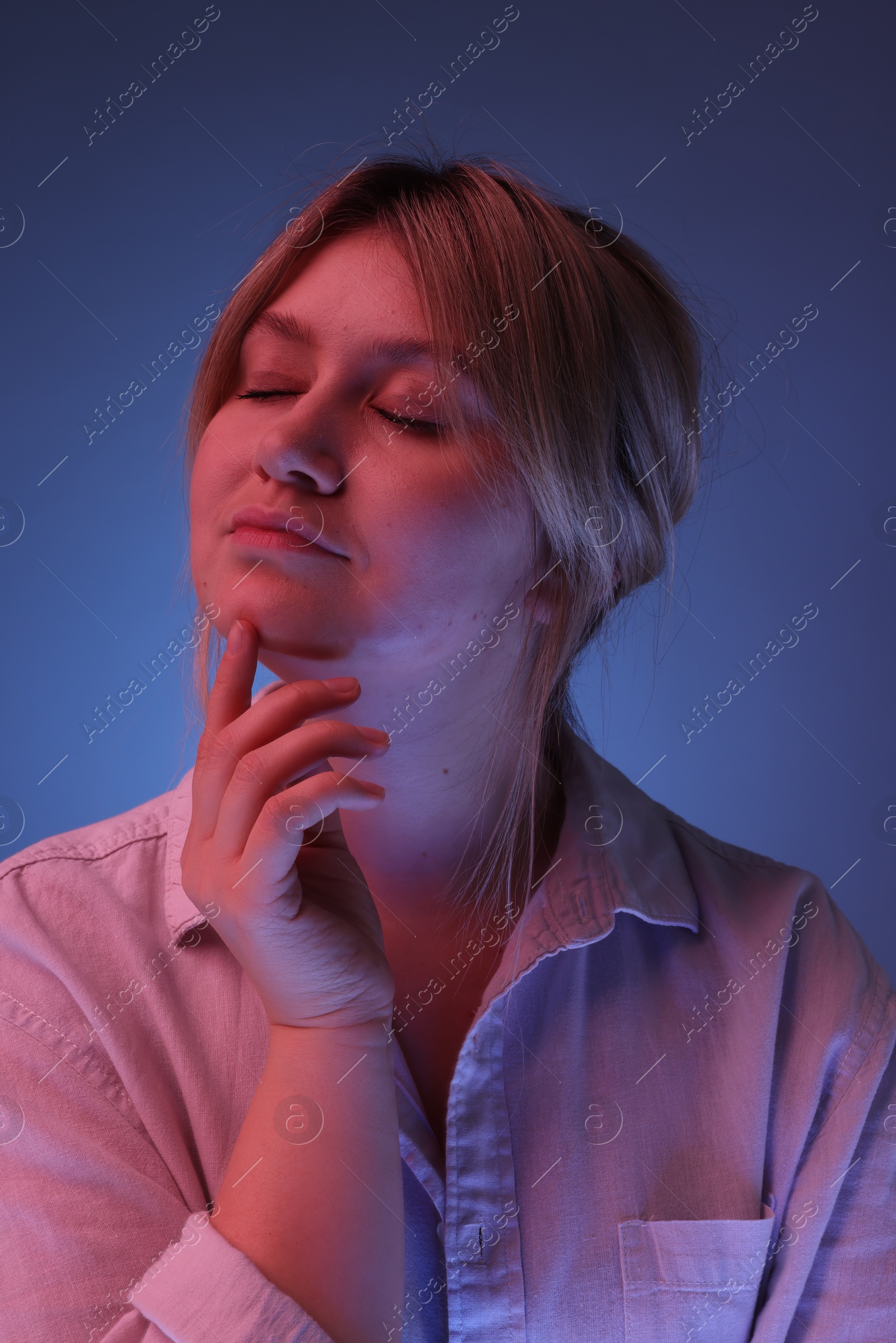 Photo of Portrait of beautiful young woman on color background with neon lights