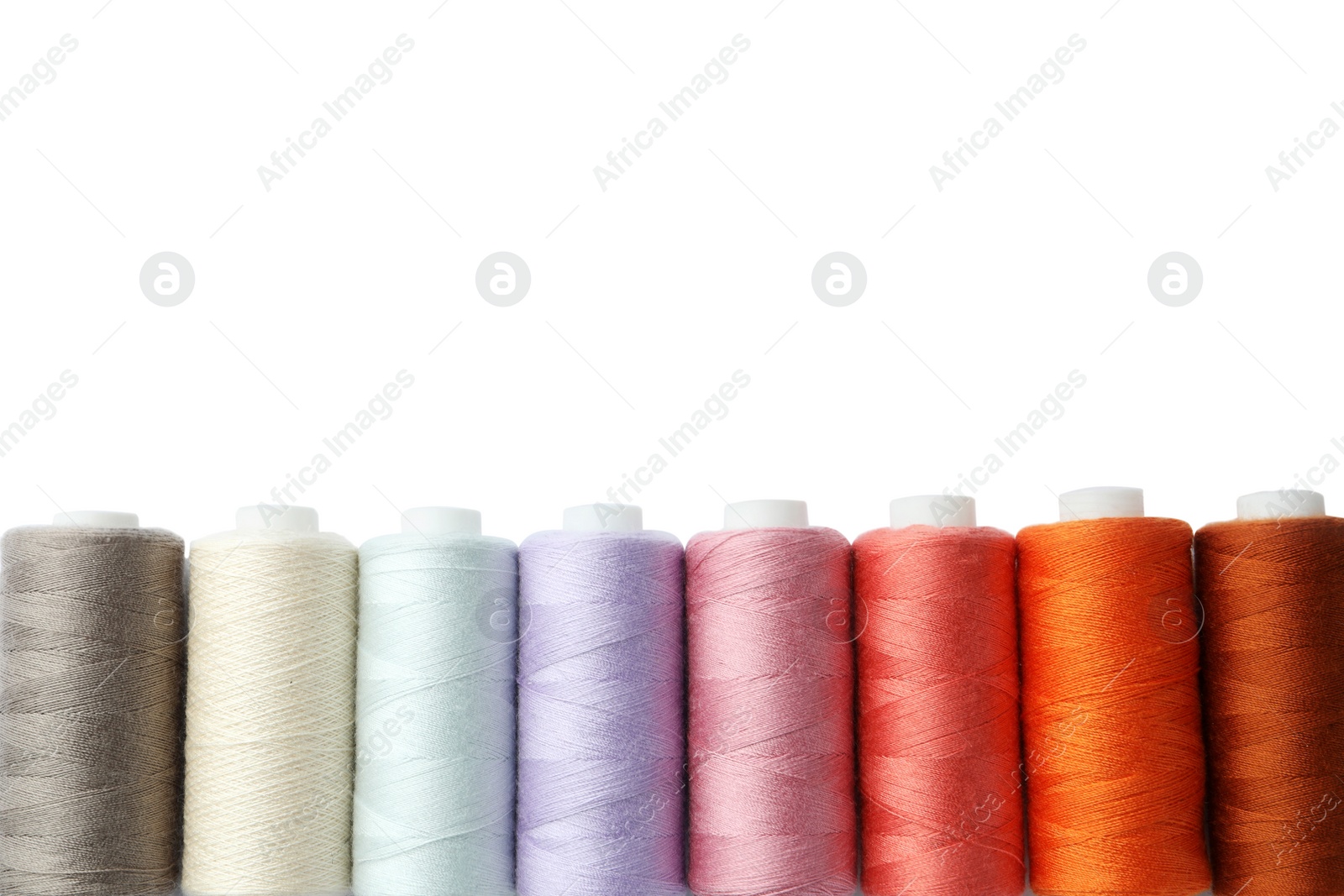 Photo of Set of different colorful sewing threads on white background, top view