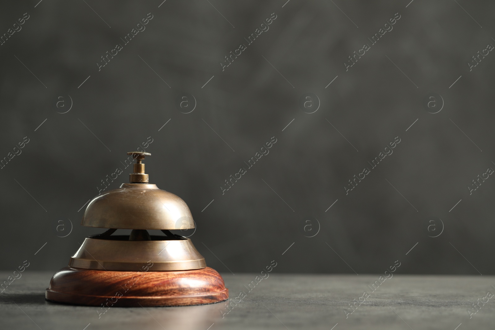 Photo of Hotel service bell on grey table. Space for text