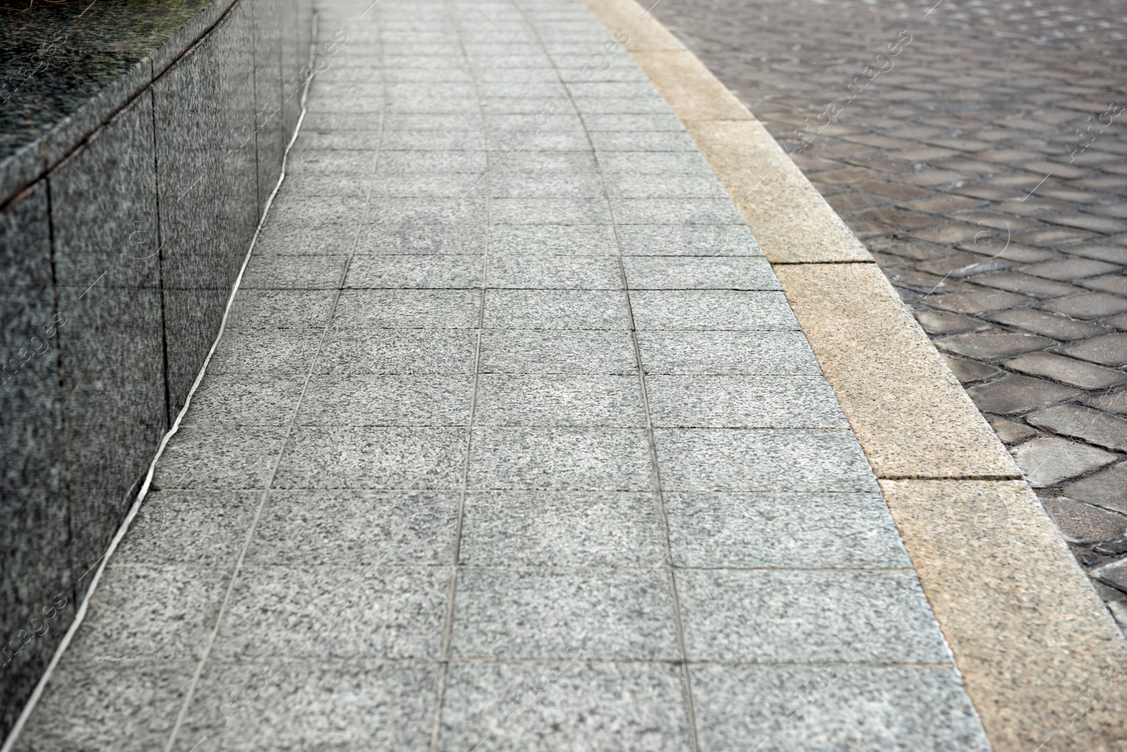 Photo of View on empty stone sidewal. Footpath covering