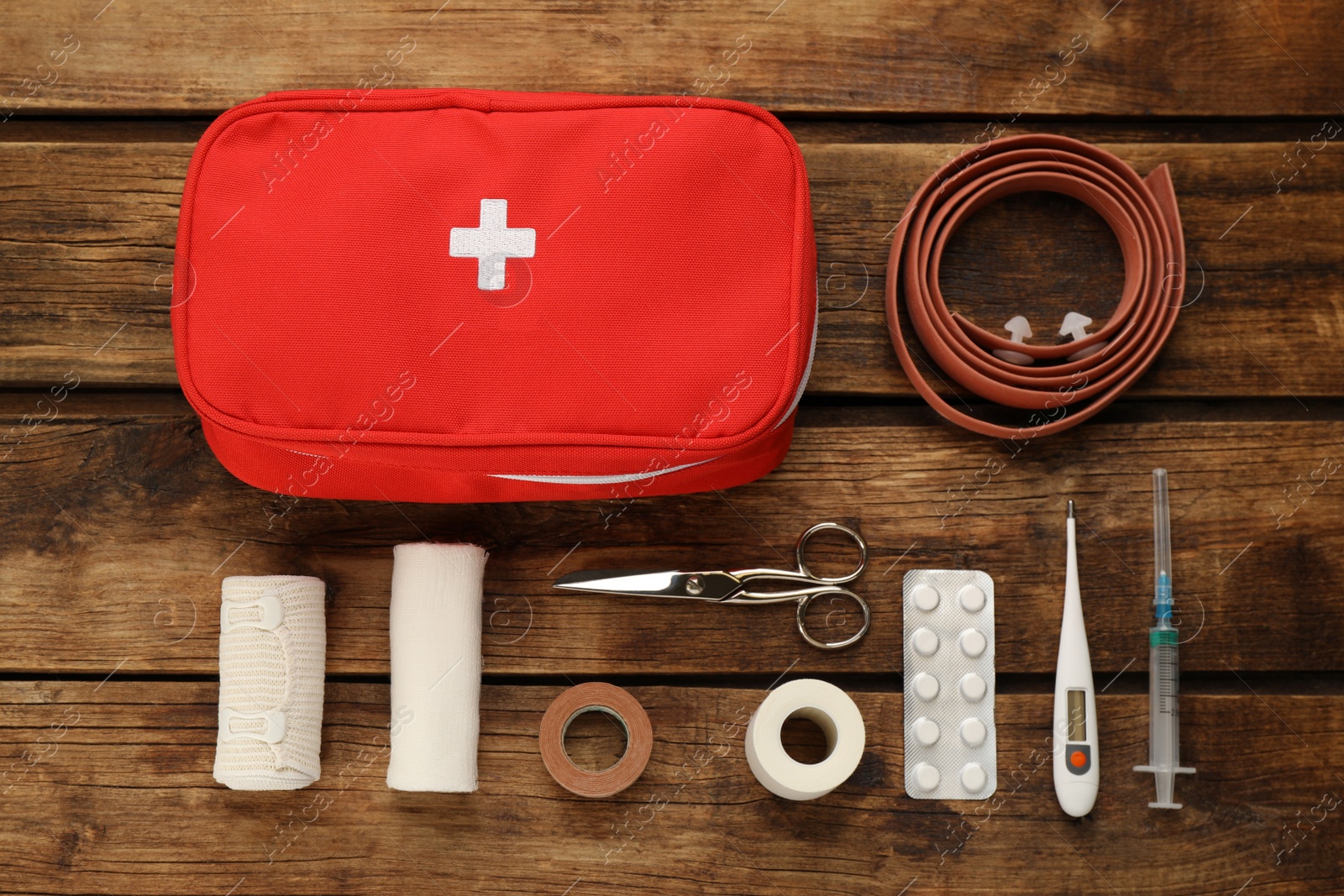 Photo of First aid kit on wooden table, flat lay