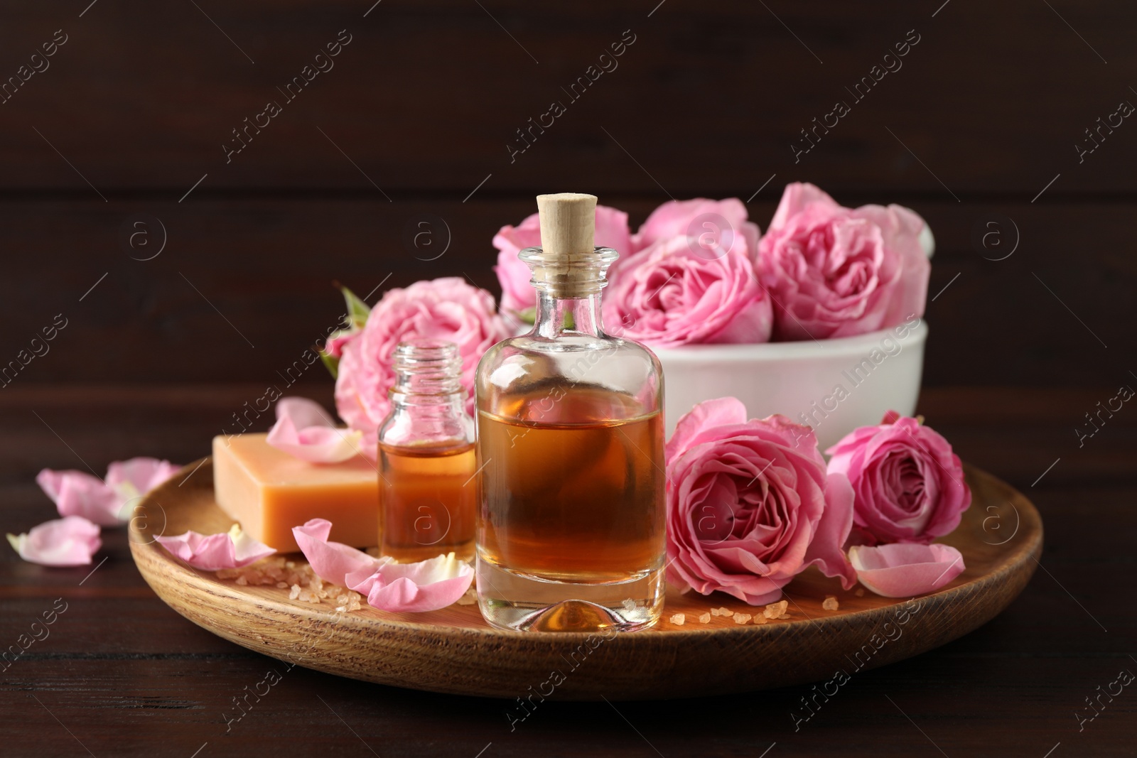 Photo of Composition with aroma oil and flowers on wooden table