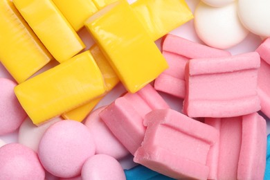 Different tasty colorful bubble gums as background, closeup