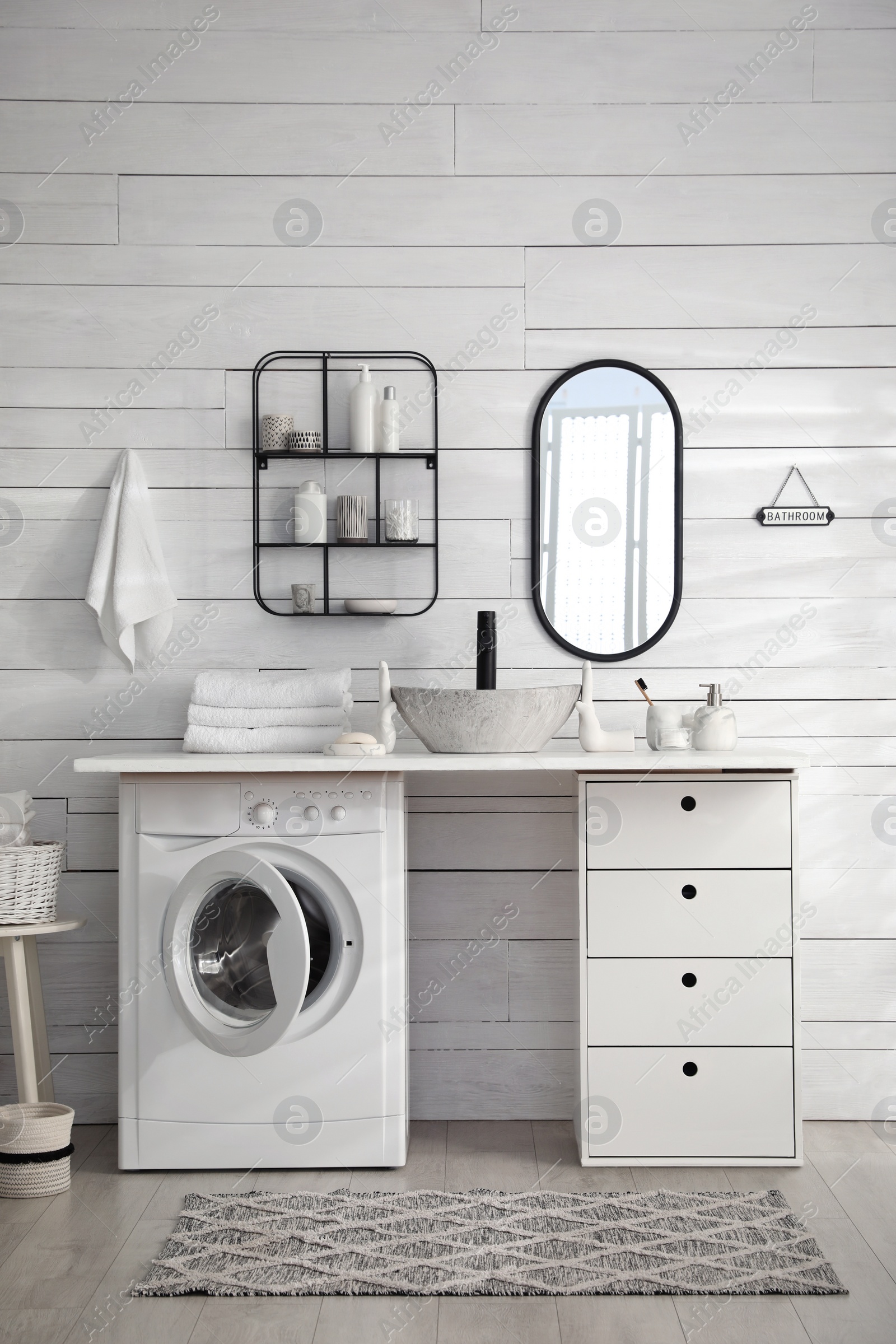 Photo of Stylish bathroom interior with modern washing machine