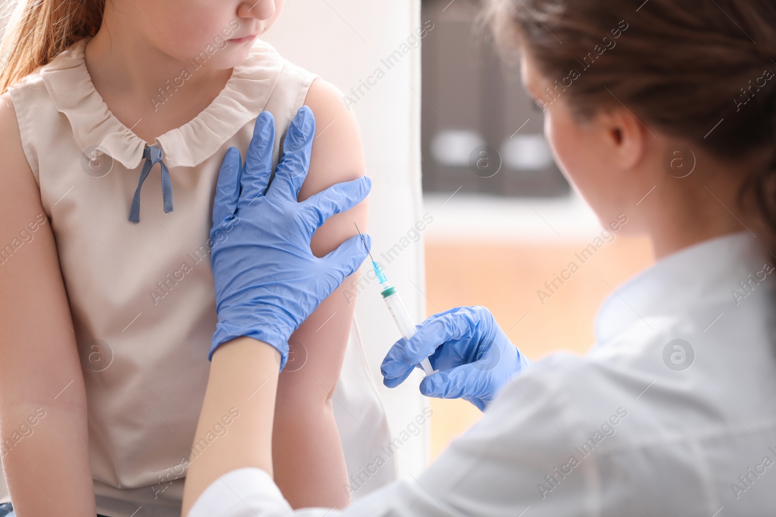 Photo of Little girl receiving chickenpox vaccination in clinic. Varicella virus prevention