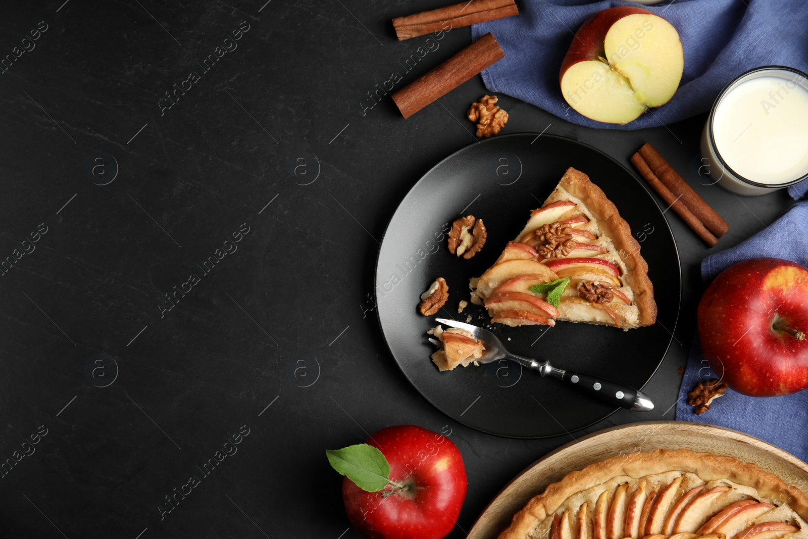 Photo of Delicious apple pie served on black table, flat lay. Space for text