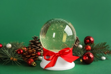 Photo of Beautiful Christmas snow globe and festive decor on green background