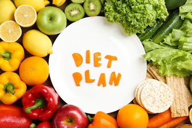 Flat lay composition with healthy food and words "DIET PLAN" on plate. Concept of weight loss