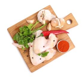 Photo of Raw chicken wings with spices and parsley on white background, top view