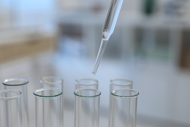 Laboratory analysis. Dripping liquid into test tubes indoors, closeup