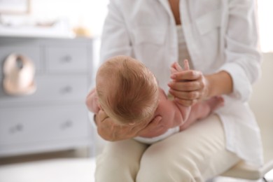 Photo of Mother holding her little baby in bedroom