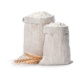 Photo of Sacks with flour and wheat spikes on white background
