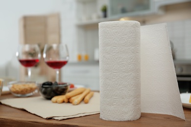 Roll of paper towels on table in kitchen, space for text