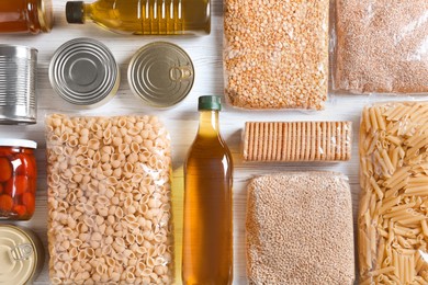 Photo of Different products on white wooden table, flat lay. Food donation