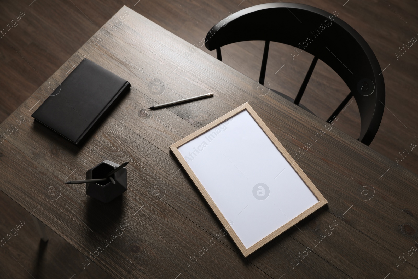 Photo of Modern wooden table with stationery and chair indoors