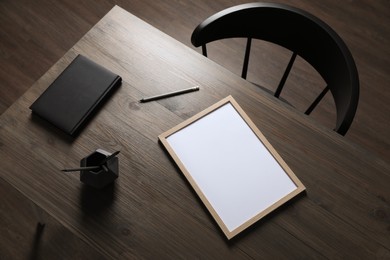 Photo of Modern wooden table with stationery and chair indoors