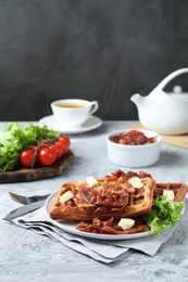 Photo of Delicious Belgium waffles served with fried bacon and butter on grey table, space for text