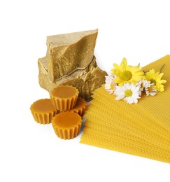 Different natural beeswax blocks, flowers and sheets on white background