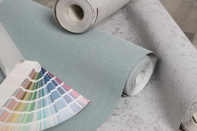 Photo of Wall paper rolls and color palette on wooden floor