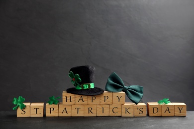 Words Happy St. Patrick's day, hat and festive decor on black background. Space for text