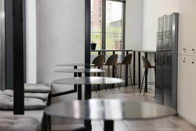 Photo of Hostel dining room interior with modern furniture and refrigerators